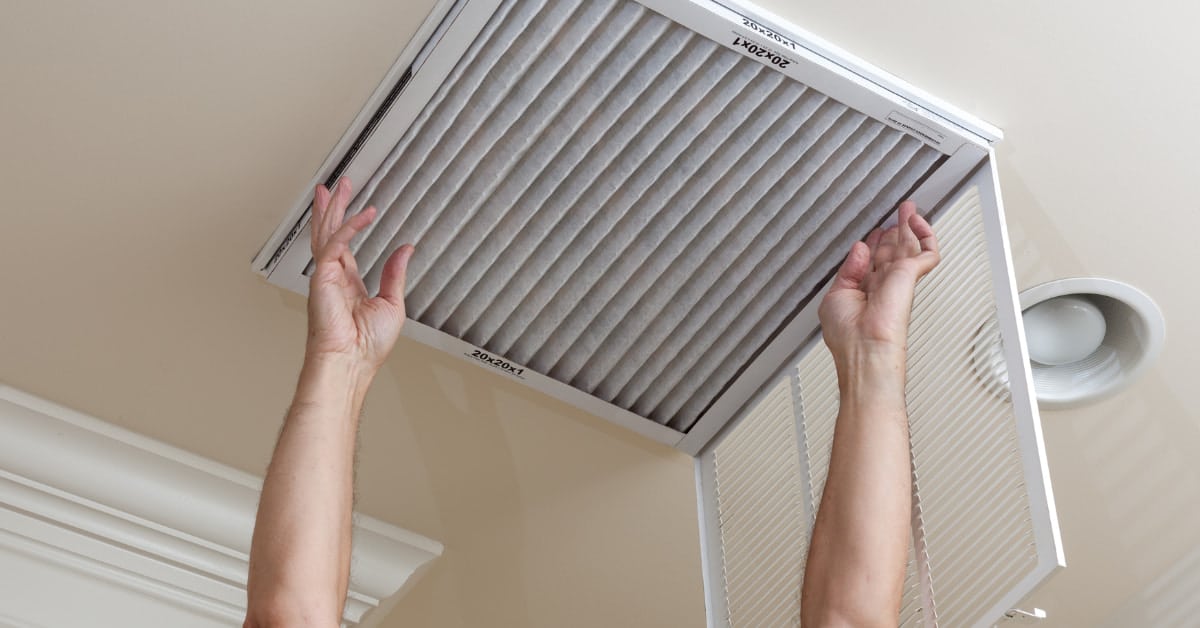 Homeowner replacing air filter for summer cooling effiency