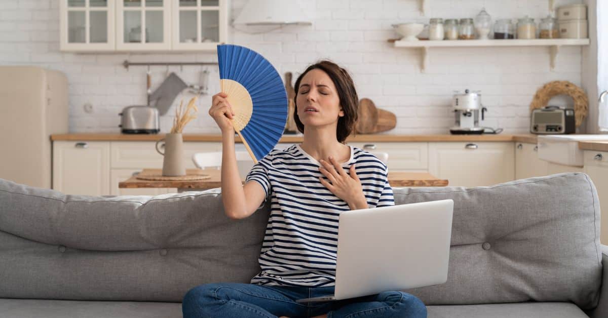 An uncomfortable homeowner looking for summer hvac tips to prevent overheating home